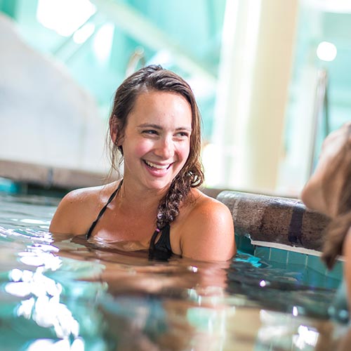 Women laughing in hot tub at indoor water park