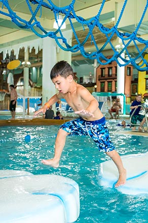 Boy crossing icebergs at Avalanche Bay Indoor Waterpark