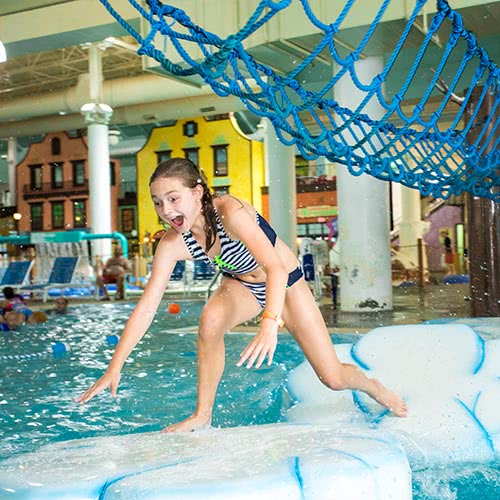 Girl balancing on faux icebergs in pool at water park