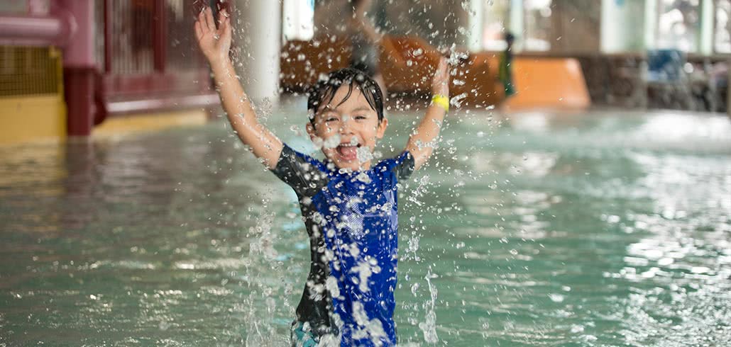 Toddler boy Splashing in Pool at water park