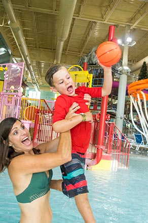 Mom and Son dunking basketball in Pool at water park